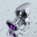 Серебристая коническая анальная пробка с фиолетовым кристаллом - 7 см.